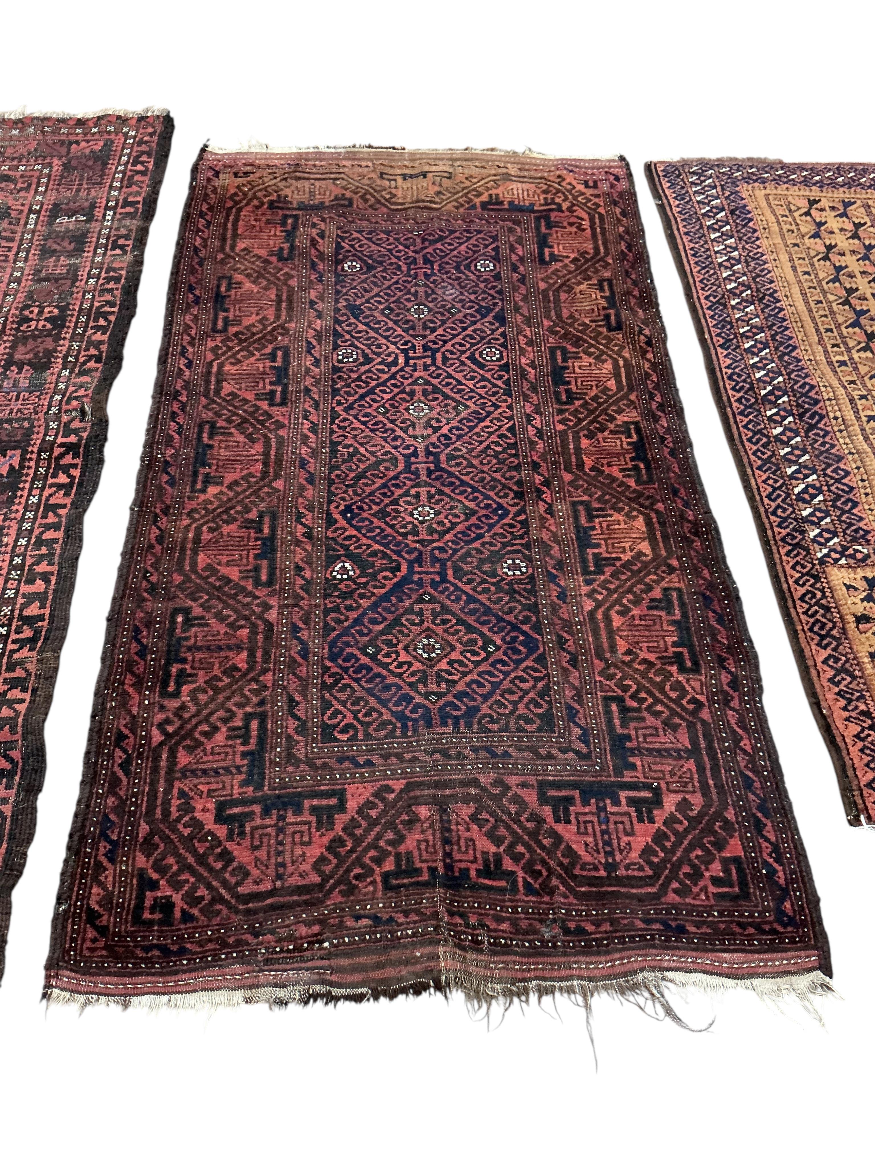Two Belouch tribal rugs and an Afghan tribal rug, largest 200 x 110cm